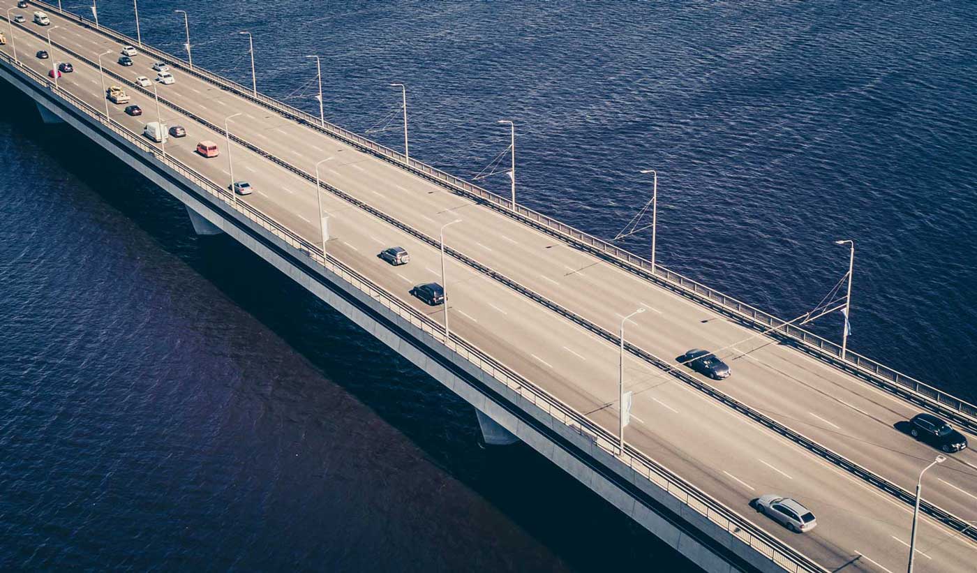 A bridge over water with several cars driving across it