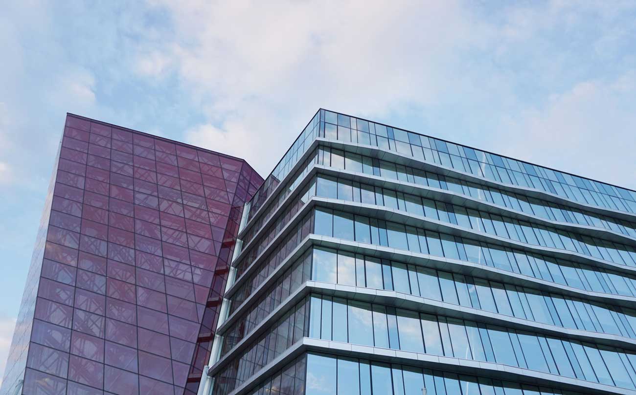 Office building reflecting cloudy sky