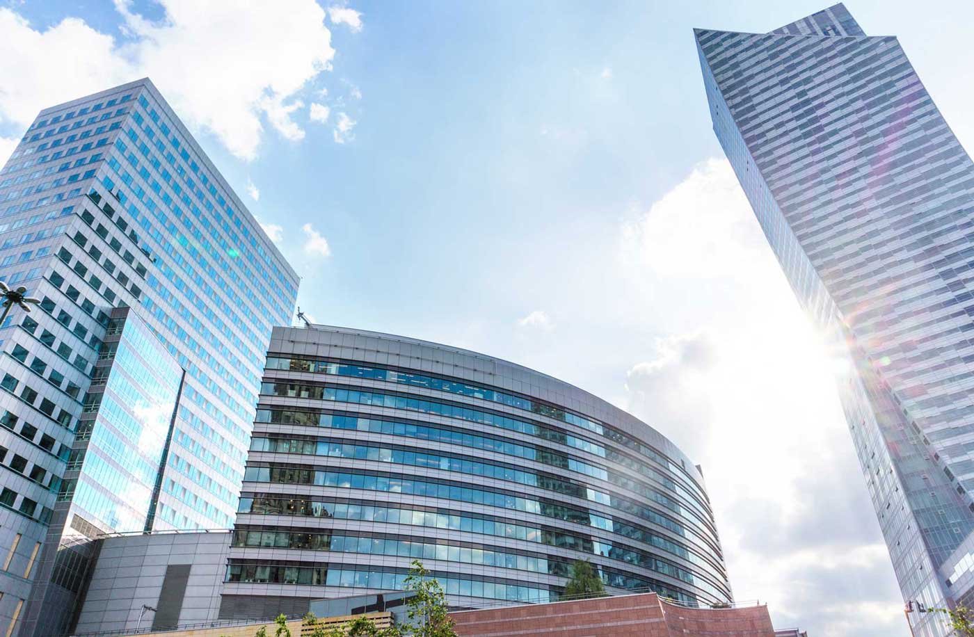 several office buildings backlit by sunlight in a city