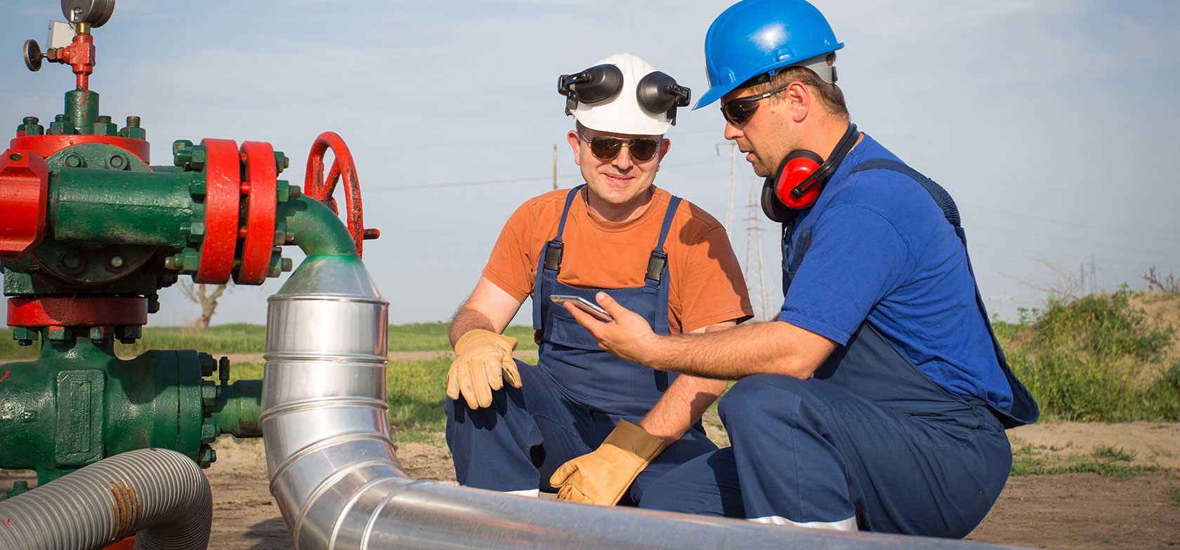 Two Icenhower employees work on equipment while using a tablet