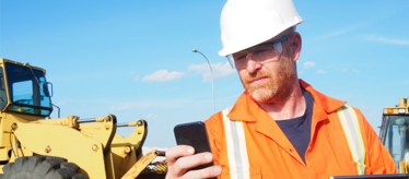 Field service technician using mobile form while wearing safety gear